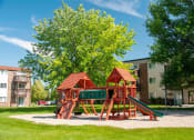 Thumbnail 4 of 50 - a playground in the middle of a yard with trees and apartment buildings