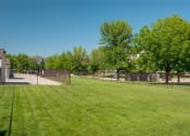 Thumbnail 15 of 30 - a fenced in backyard with a grass field and trees