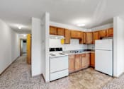 Thumbnail 30 of 38 - a kitchen with white appliances and wooden cabinets