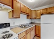 Thumbnail 33 of 38 - a kitchen with white appliances and wooden cabinets