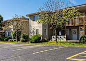 Thumbnail 11 of 38 - a building with a porch and a parking lot