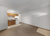 Thumbnail 27 of 38 - the living room and kitchen of an apartment with white walls and wood cabinets