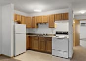 Thumbnail 23 of 38 - an empty kitchen with white appliances and wooden cabinets