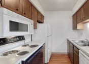 Thumbnail 41 of 45 - an empty kitchen with white appliances and wooden cabinets