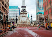 Thumbnail 16 of 16 - A city street with a tall white monument in the middle.