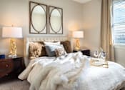 Thumbnail 6 of 25 - A bedroom with a large bed covered in a white fur throw at The Olivia Apartments, Indiana