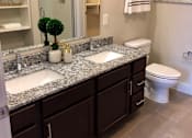 Thumbnail 10 of 25 - A bathroom with a double sink vanity and a toilet at The Olivia Apartments, Carmel, IN