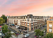 Thumbnail 17 of 35 - A large building with a lot of windows is surrounded by trees and cars.