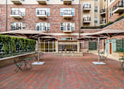 Thumbnail 18 of 35 - A patio with tables and chairs and a fireplace.