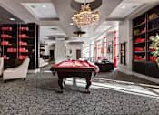Thumbnail 28 of 35 - A room with a pool table and a chandelier.