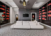 Thumbnail 24 of 35 - A living room with a white couch and a television on the wall.