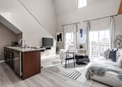 Thumbnail 20 of 35 - A modern living room with a kitchen area and a staircase.