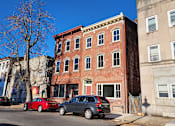 Thumbnail 7 of 7 - A red brick building with a green lawn in front.