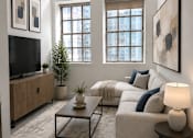 Thumbnail 8 of 20 - A living room with a couch, a coffee table, and a television.