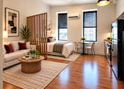 Thumbnail 8 of 15 - A modern living room with a white sofa, wooden coffee table, and a large window.