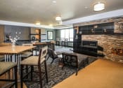 Thumbnail 20 of 33 - a community room with tables and chairs and a fireplace at The Flats at Cedar Grove, Minnesota, 55122