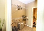 Thumbnail 11 of 33 - a walk in closet in a bedroom with a door to a bathroom at The Flats at Cedar Grove, Minnesota