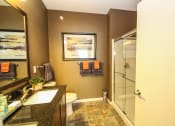 Thumbnail 13 of 33 - a bathroom with a toilet a sink and a shower at The Flats at Cedar Grove, Eagan, MN