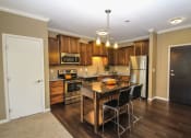 Thumbnail 9 of 33 - a kitchen with a large island and stainless steel appliances at The Flats at Cedar Grove, Minnesota