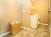 Thumbnail 7 of 33 - a laundry room with a large basket and a washer and dryer at The Flats at Cedar Grove, Eagan, Minnesota
