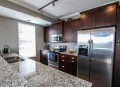Thumbnail 31 of 44 - a kitchen with granite countertops and stainless steel appliances  at Victoria Park and V2 Apartments, St. Paul, MN, 55102