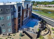Thumbnail 30 of 33 - an aerial view of a building with a pool in front of it at The Flats at Cedar Grove, Eagan