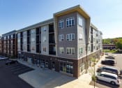 Thumbnail 32 of 33 - a large apartment building with a parking lot in front of it at The Flats at Cedar Grove, Minnesota, 55122