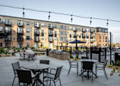 Thumbnail 5 of 43 - an outdoor patio with tables chairs and grills at The Gallery Apartments, Burnsville