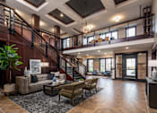 Thumbnail 37 of 43 - a reception area with couches a coffee table and a stairway to the second floor at The Gallery Apartments, Burnsville, Minnesota