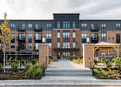 Thumbnail 43 of 43 - a picture of the front of a building with a walkway and gazebo at The Gallery Apartments, Burnsville, Minnesota