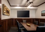 Thumbnail 13 of 44 - a conference room with a table and chairs and a tv on the wall  at Victoria Park and V2 Apartments, St. Paul, 55102