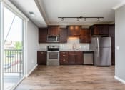 Thumbnail 16 of 44 - a kitchen with dark wood cabinets and stainless steel appliances  at Victoria Park and V2 Apartments, Minnesota