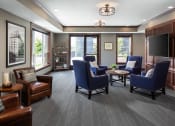 Thumbnail 10 of 44 - a community room filled with furniture and a large window  at Victoria Park and V2 Apartments, St. Paul, 55102