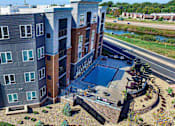 Thumbnail 31 of 33 - an aerial view of a building with a pool in front of it at The Flats at Cedar Grove, Eagan