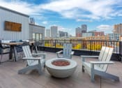 Thumbnail 31 of 42 - Rooftop deck with lounge seating and gas firepit overlooking park and skyline. at The Whitley, St. Paul
