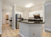 Thumbnail 15 of 25 - A kitchen with a refrigerator, stove, and oven. at Puller Place Apartments, Jacksonville, NC