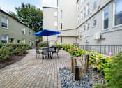 Thumbnail 31 of 42 - a patio with a table and chairs and an umbrella at Queen Anne Belvedere, Baltimore, Maryland