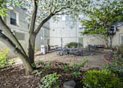 Thumbnail 27 of 42 - a courtyard with a tree and a table and chairs at Queen Anne Belvedere, Baltimore, 21201
