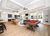 Thumbnail 5 of 35 - A pool table is in the middle of a room with a ceiling fan at The Promenade at Easton Apartments, Easton, MD 21601