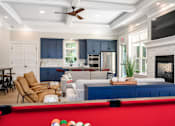 Thumbnail 7 of 35 - A pool table with a red cloth and white balls is in the foreground of a well-lit room with a fireplace and a television at The Promenade at Easton Apartments, Easton Maryland