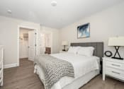 Thumbnail 14 of 35 - A bedroom with a large bed and a painting on the wall at The Promenade at Easton Apartments, Easton, 21601
