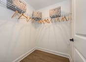 Thumbnail 16 of 35 - A hallway with a white wall and a wooden floor with a metal rack on the wall at The Promenade at Easton Apartments, Maryland, 21601