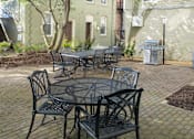 Thumbnail 20 of 42 - a patio with a table and chairs in front of a building at Queen Anne Belvedere, Baltimore, MD 21201