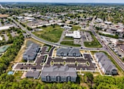 Thumbnail 35 of 35 - A bird's eye view of a large building complex surrounded by a parking lot and a road.