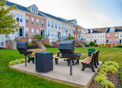 Thumbnail 18 of 50 - a park with a picnic table and benches in front of a building at Townes at Village Center Apartments, Reisterstown, MD, 21136