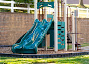 Thumbnail 20 of 50 - a playground with a slide and a swing set at Townes at Village Center Apartments, Reisterstown, MD