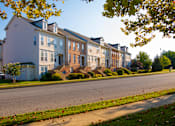 Thumbnail 13 of 50 - a row of houses on the side of a street at Townes at Village Center Apartments, Reisterstown, Maryland