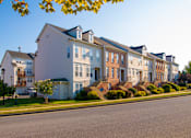 Thumbnail 41 of 50 - a row of houses on the side of a street at Townes at Village Center Apartments, Maryland