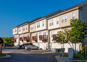 Thumbnail 49 of 50 - an apartment building with cars parked in front of it at Townes at Village Center Apartments, Reisterstown, 21136
