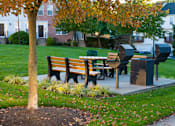 Thumbnail 36 of 50 - a picnic table in a park next to a tree at Townes at Village Center Apartments, Reisterstown, MD